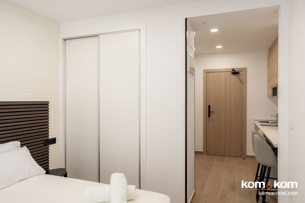 Interior de armario de dormitorio con puertas correderas y tiras de iluminaci&oacute;n LED integradas. Soluci&oacute;n de almacenaje elegante y funcional de Kom&Kom en Benidorm.